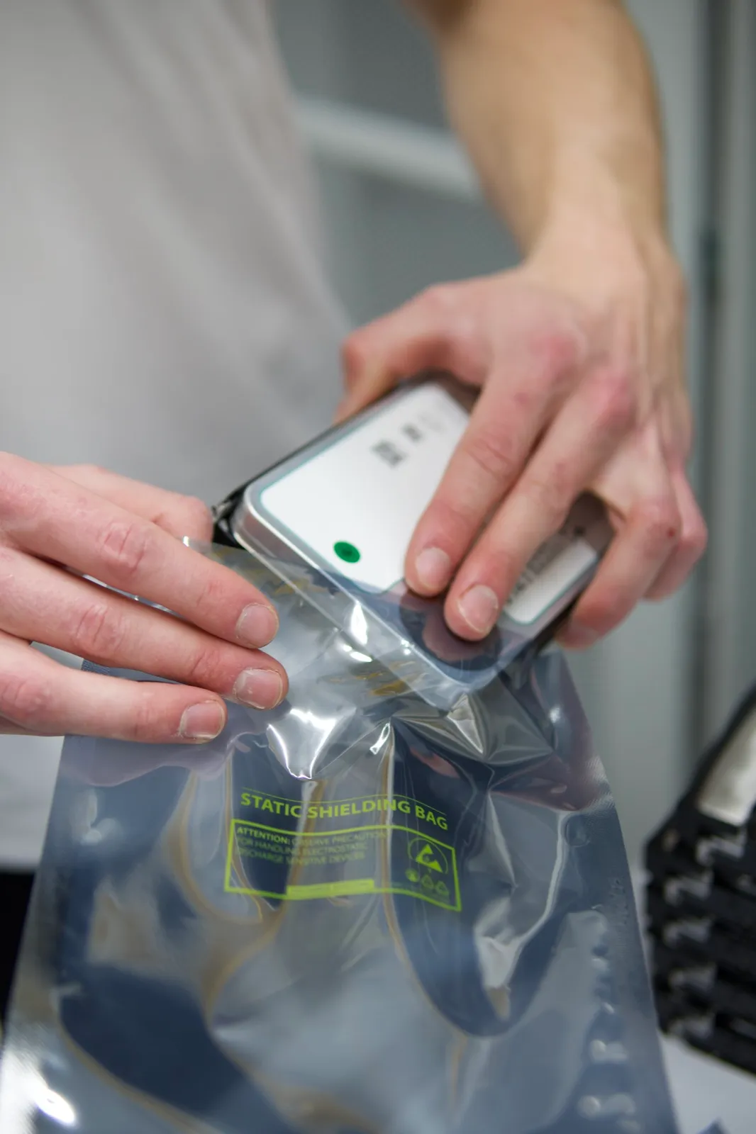 A retired hard drive being sealed into a static shielding bag for secure handling