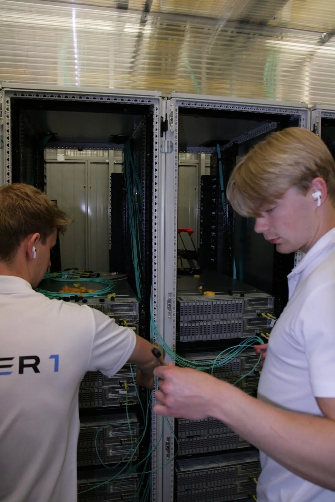 Two Layer One engineers patching fiber cross connects at Nikhef