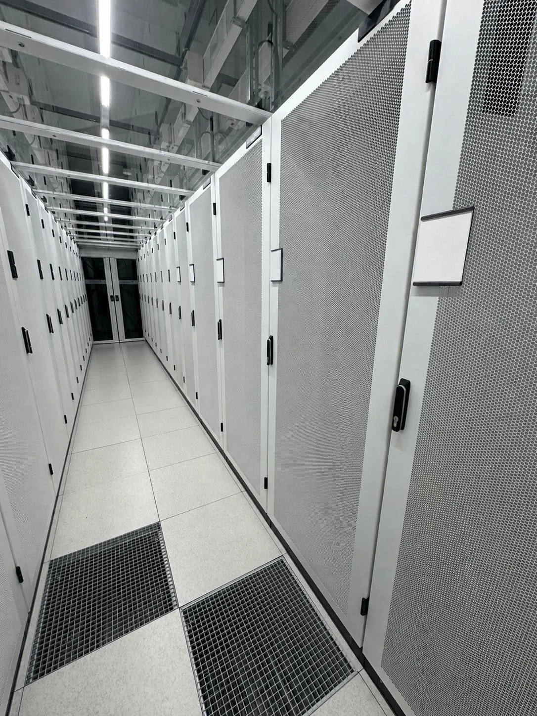 Server cabinets lining an aisle inside the Nikhef interconnection facility at Amsterdam Science Park