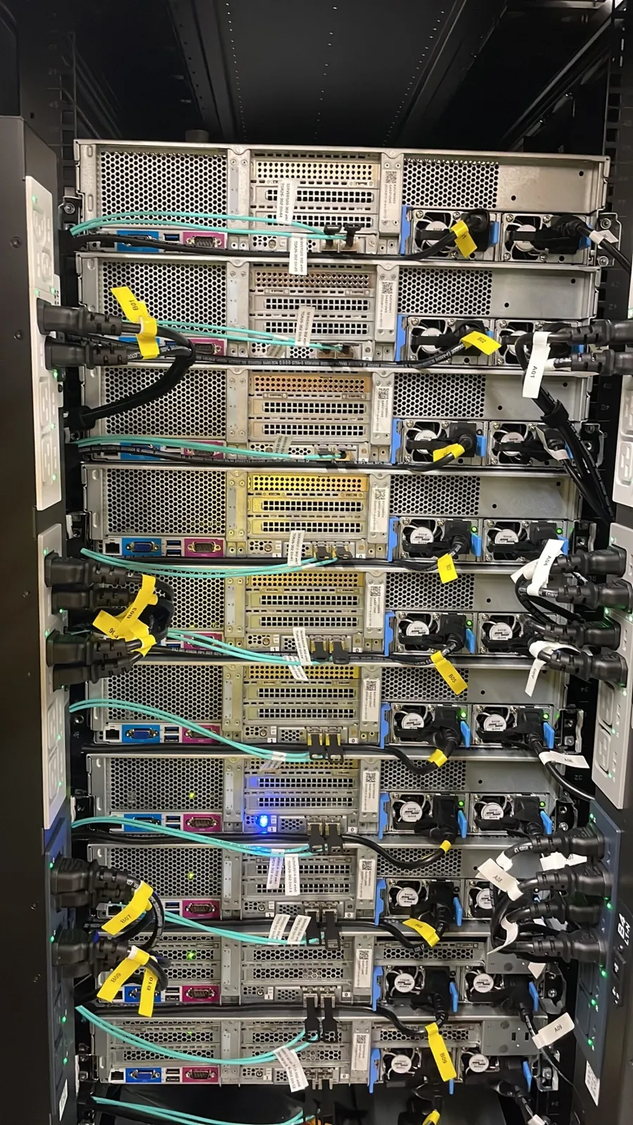 The rear of a server rack with labeled power and network cabling