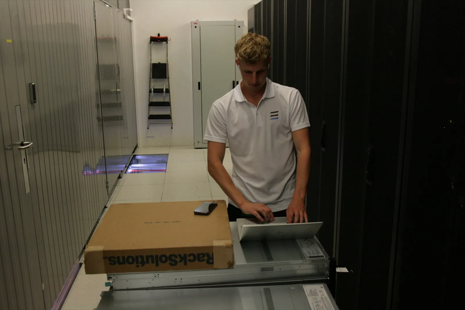 A Layer One engineer mounting server rails on site
