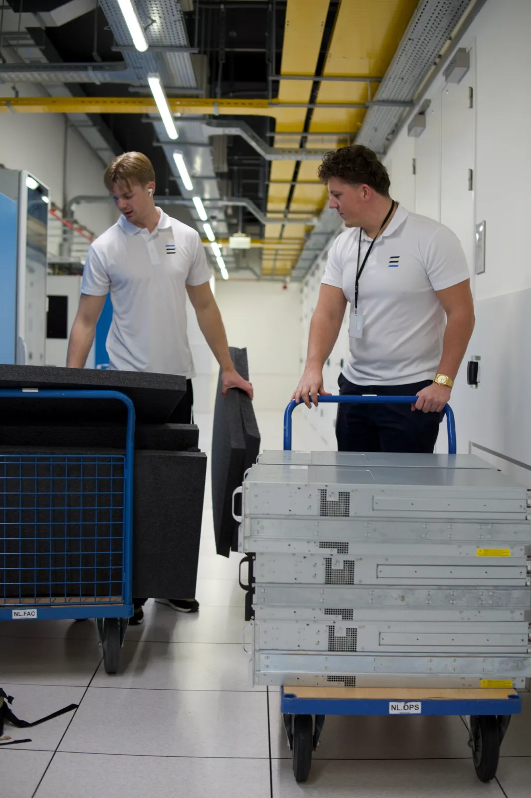 Layer One engineers moving server hardware on transport carts through a datacenter
